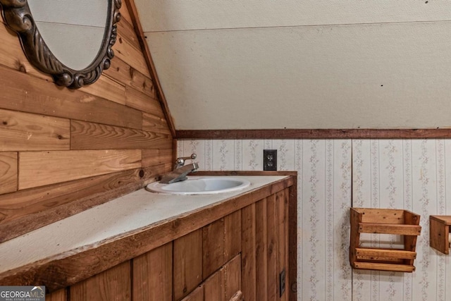 bathroom with wallpapered walls and vanity