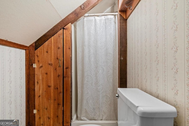 bathroom featuring curtained shower and wallpapered walls