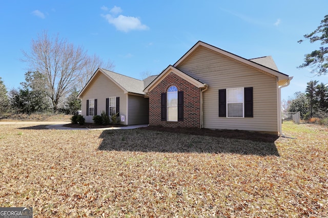 ranch-style home featuring brick siding and a front lawn