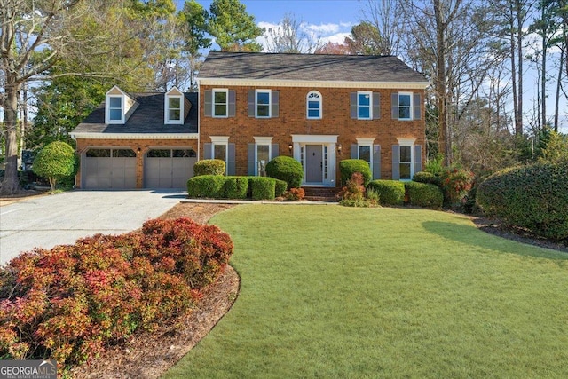 colonial home with a garage, a front yard, brick siding, and driveway