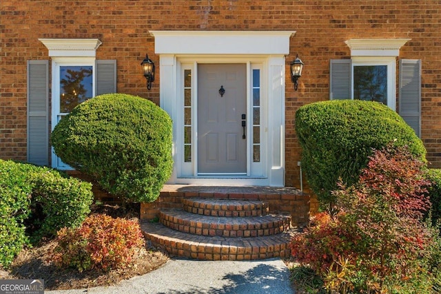 property entrance featuring brick siding