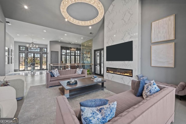 living room featuring visible vents, an inviting chandelier, a high ceiling, a fireplace, and recessed lighting