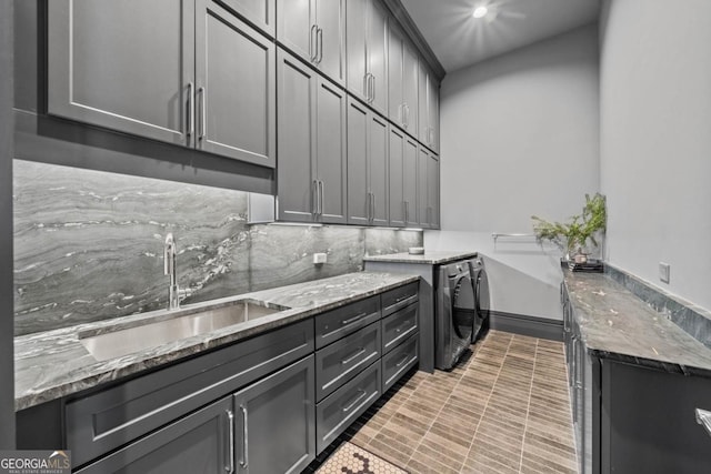 clothes washing area featuring cabinet space, washer and clothes dryer, a sink, and recessed lighting