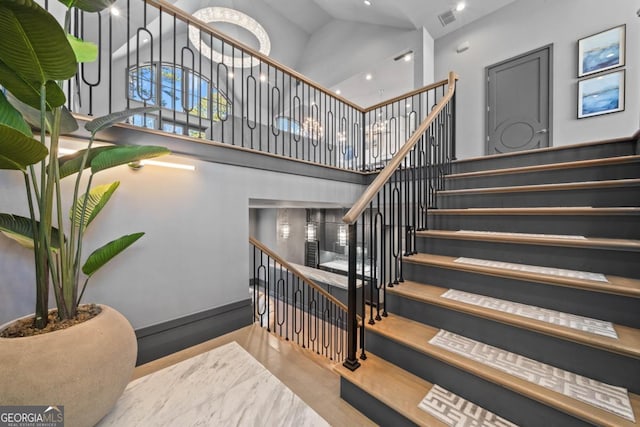 stairway with a towering ceiling and visible vents