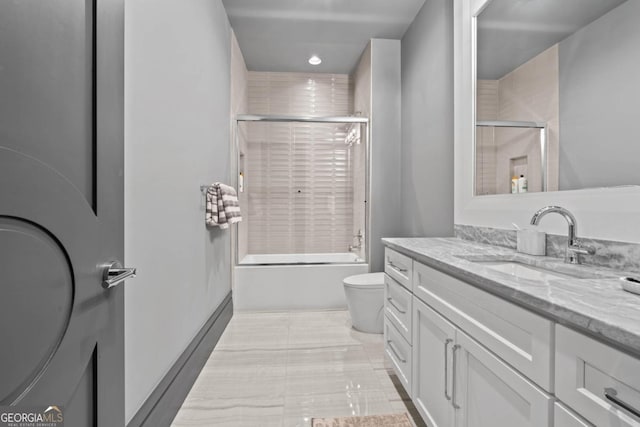 bathroom with toilet, combined bath / shower with glass door, and vanity