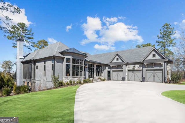 view of front of home featuring driveway, metal roof, an attached garage, a standing seam roof, and a front yard