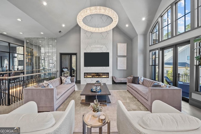 living area featuring high vaulted ceiling, french doors, a premium fireplace, and recessed lighting