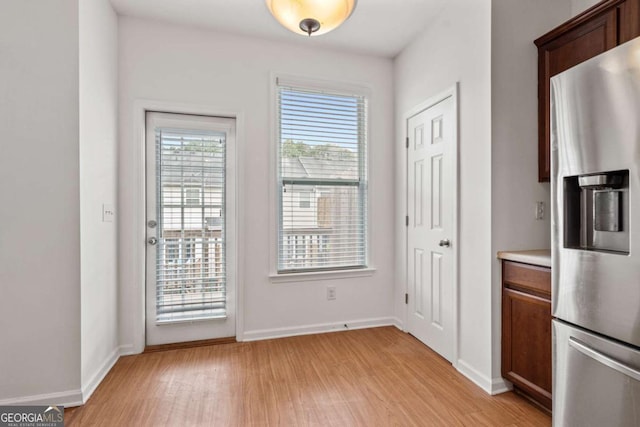 entryway with light wood-style flooring and baseboards