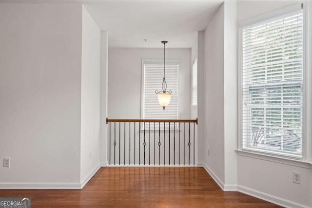 empty room featuring dark wood-style flooring and baseboards