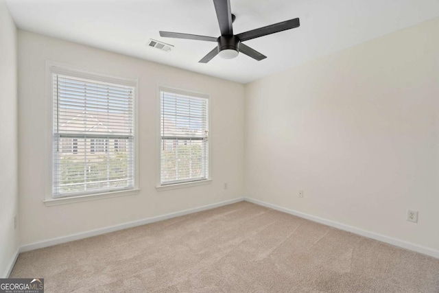 spare room with light carpet, baseboards, and visible vents