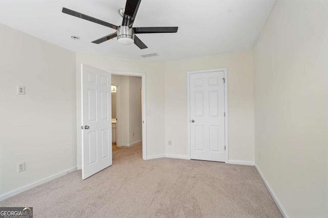 unfurnished bedroom featuring a ceiling fan, light colored carpet, visible vents, and baseboards