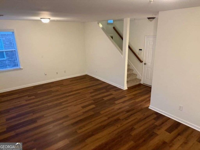 finished basement featuring dark wood-style floors, baseboards, and stairs