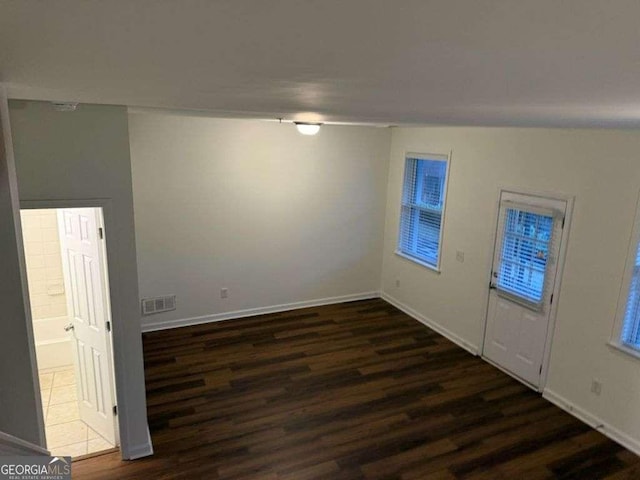 interior space featuring baseboards, visible vents, and dark wood-style flooring