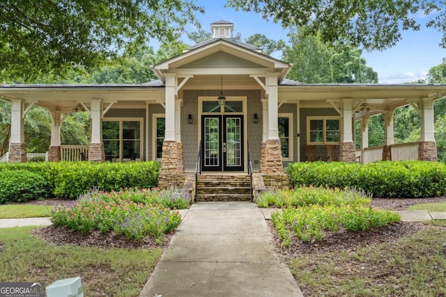 doorway to property featuring covered porch and stone siding