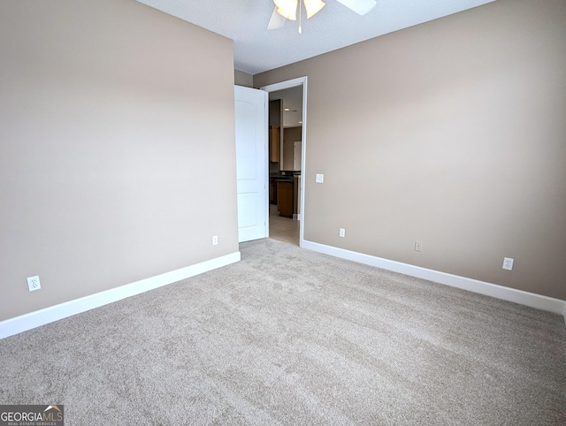 unfurnished room with light colored carpet, ceiling fan, and baseboards