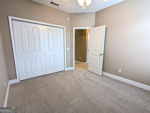 unfurnished bedroom with ceiling fan, light carpet, visible vents, baseboards, and a closet