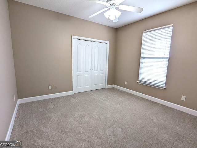 unfurnished bedroom featuring carpet, a closet, and baseboards