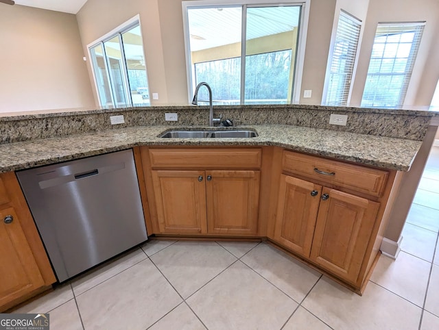 kitchen featuring a sink, light stone countertops, brown cabinetry, and dishwasher