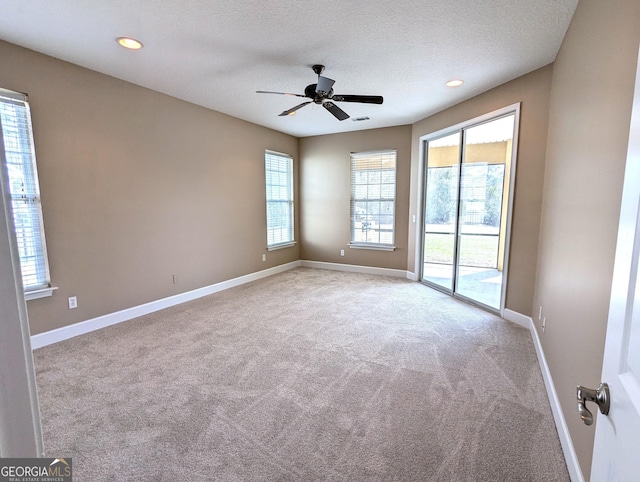 unfurnished room with a textured ceiling, recessed lighting, light colored carpet, a ceiling fan, and baseboards