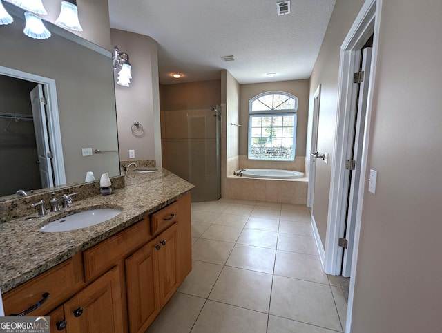 full bathroom with visible vents, a spacious closet, a stall shower, vanity, and tile patterned flooring