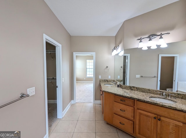 bathroom with double vanity, a sink, toilet, and tile patterned floors