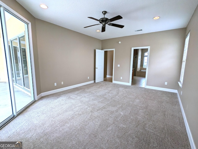 unfurnished bedroom featuring access to outside, multiple windows, visible vents, and light colored carpet