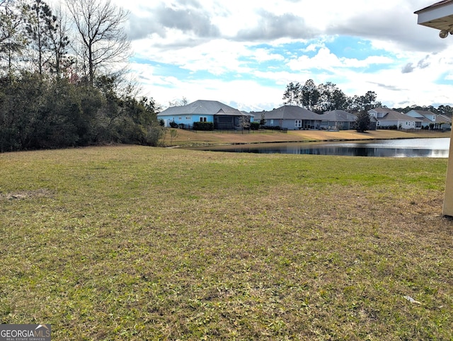 view of yard featuring a residential view and a water view