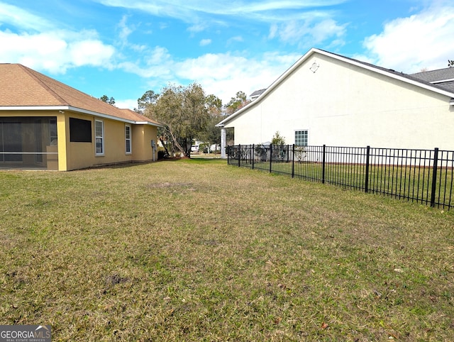 view of yard with a sunroom and fence