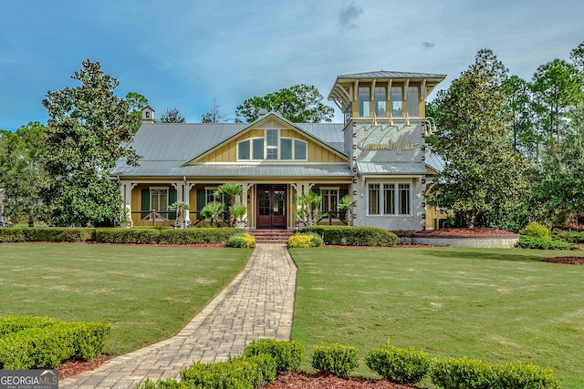 view of front of house with metal roof, a front lawn, a standing seam roof, and a chimney