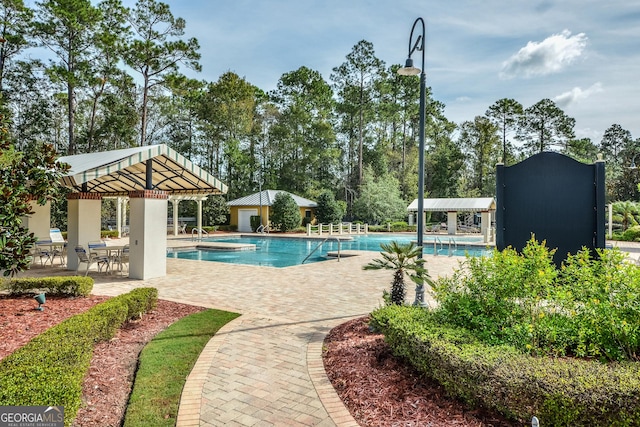 community pool with an outdoor structure, a patio, and a gazebo