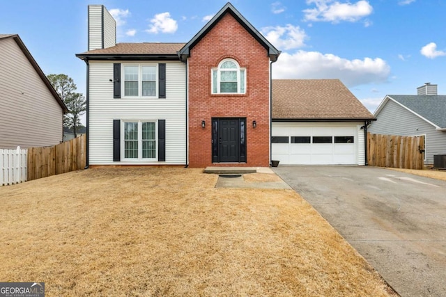 view of front of house with aphalt driveway, brick siding, a chimney, an attached garage, and fence