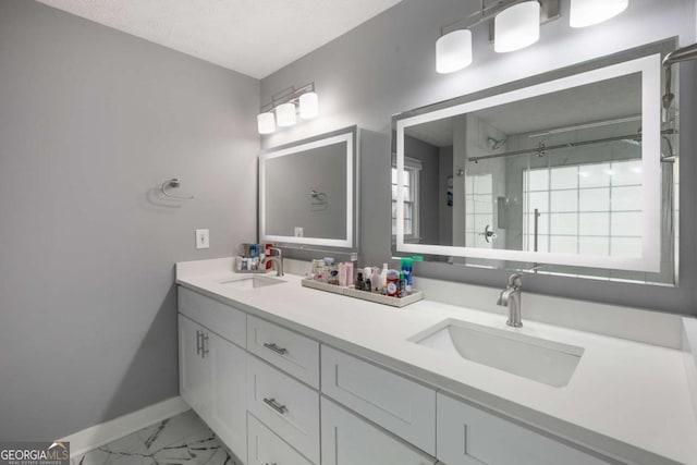 bathroom featuring a shower stall, marble finish floor, a sink, and baseboards