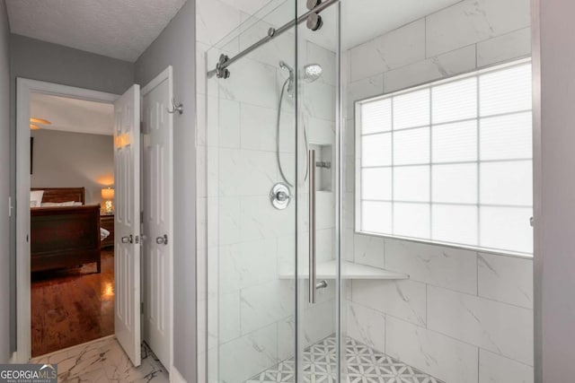 full bath featuring marble finish floor, connected bathroom, a shower stall, and a textured ceiling