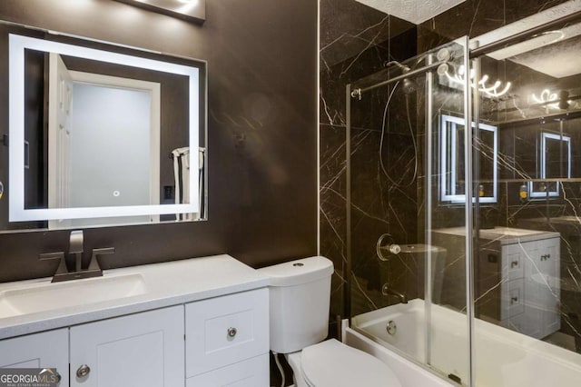 bathroom with combined bath / shower with glass door, vanity, and toilet