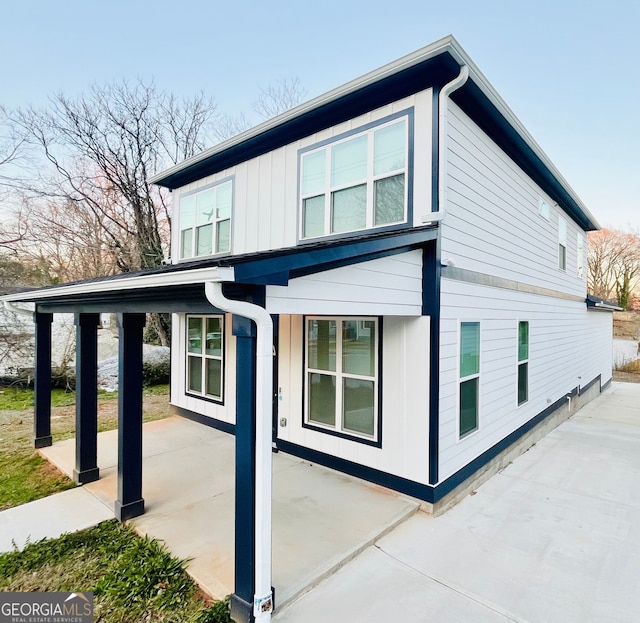 view of side of home featuring a patio and board and batten siding