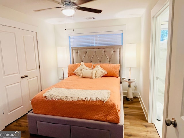 bedroom with visible vents, wood finished floors, a ceiling fan, and baseboards