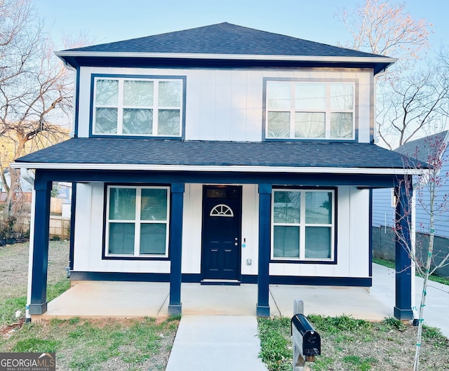 view of front of property with covered porch, board and batten siding, and roof with shingles