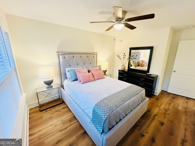 bedroom featuring ceiling fan, wood finished floors, and baseboards