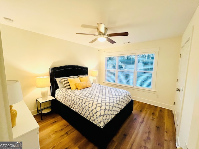 bedroom with dark wood-style floors, visible vents, and baseboards