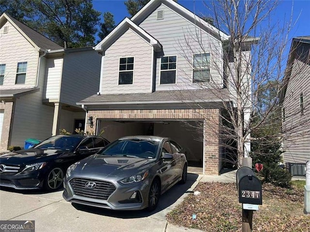 view of front of house featuring a garage, brick siding, and driveway