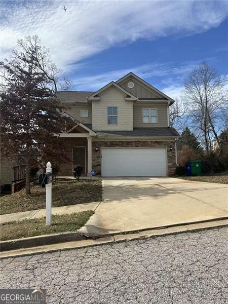 view of front of house with concrete driveway, board and batten siding, and an attached garage