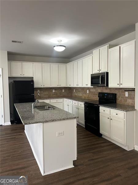 kitchen with black appliances, dark wood finished floors, visible vents, and white cabinetry