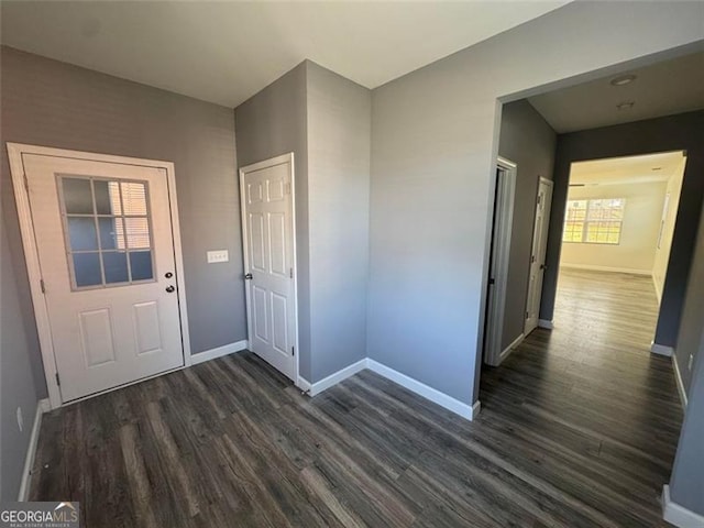 foyer featuring dark wood-style floors and baseboards