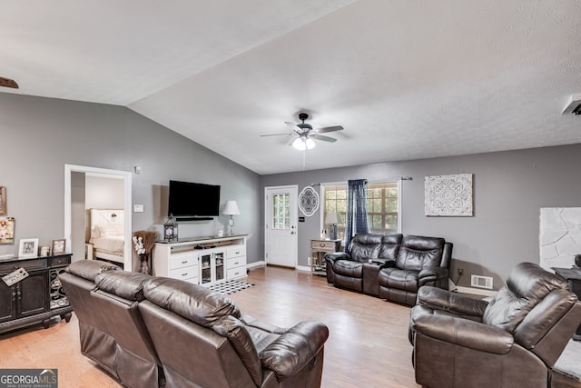 living room with lofted ceiling, visible vents, light wood-style floors, ceiling fan, and baseboards