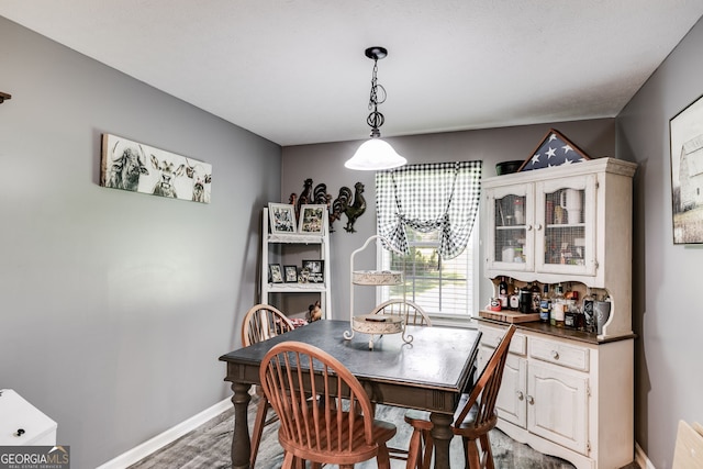 dining area with baseboards and wood finished floors