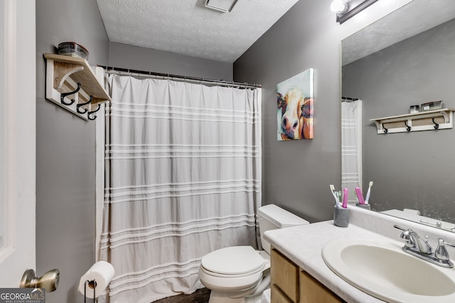 full bathroom with toilet, a textured ceiling, and vanity