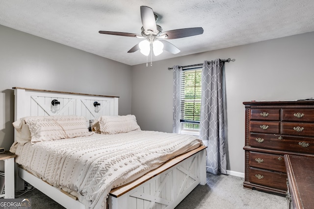 bedroom with a textured ceiling, baseboards, a ceiling fan, and light colored carpet