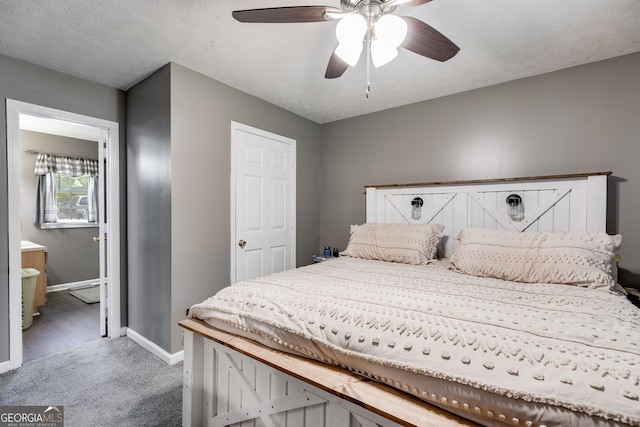 bedroom featuring baseboards, ensuite bath, ceiling fan, carpet, and a textured ceiling