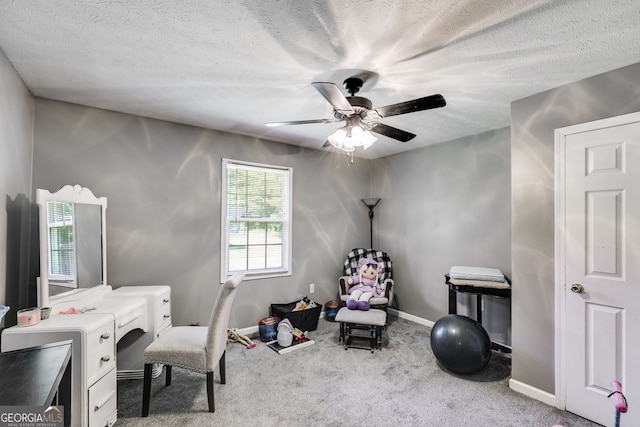 office space featuring a textured ceiling, carpet floors, ceiling fan, and baseboards