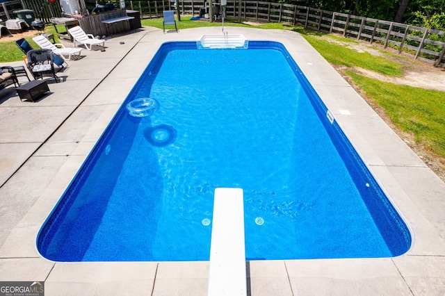 view of pool with a diving board, a patio area, a fenced backyard, and a fenced in pool